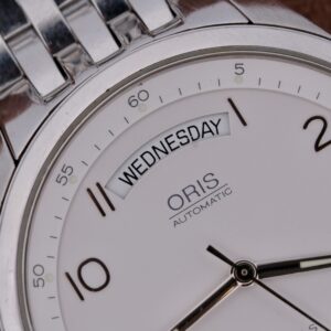 Introducing the Oris XXL Full Day Automatic Ref 7531, a timeless masterpiece crafted in Switzerland between 2000 and 2009. This exquisite timepiece features a robust 38mm stainless steel case, perfectly complemented by an original stainless steel bracelet, ensuring both durability and elegance. The pristine white dial, accented with silver-tone markers and hands, offers a sophisticated contrast, while the day/date function adds practical utility to its classic design. Powered by a reliable automatic movement, the Oris 7531 boasts self-winding capabilities, ensuring precision and convenience for the modern wearer. The hack second feature allows for precise time-setting, while the luminous markers and hands provide excellent visibility in low-light conditions. With an 18mm lug width, this watch offers a comfortable fit for any wrist size. The Oris XXL Full Day Automatic Ref 7531 is a testament to Swiss watchmaking excellence, combining functionality with timeless style. Whether for daily wear or special occasions, this watch is a perfect addition to any collection.