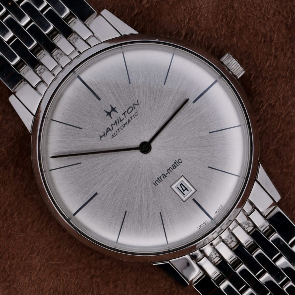 The Hamilton Intramatic Date Stainless Steel H38455151 is a sophisticated Swiss-made watch featuring the reliable 2892-2 automatic movement. It boasts a 41mm stainless steel case with a sleek silver dial, minimalist hour markers, and a discreet date function at 6 o'clock. The original 22mm stainless steel bracelet offers both comfort and durability, making it ideal for everyday wear and special occasions. This timepiece combines high-quality materials, expert craftsmanship, and timeless design, making it a distinguished addition to any watch collection.