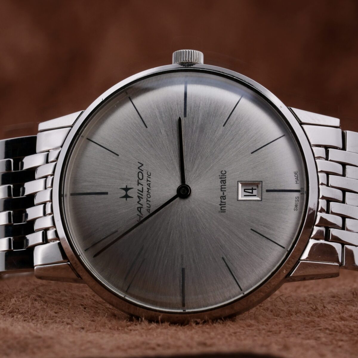 The Hamilton Intramatic Date Stainless Steel H38455151 is a sophisticated Swiss-made watch featuring the reliable 2892-2 automatic movement. It boasts a 41mm stainless steel case with a sleek silver dial, minimalist hour markers, and a discreet date function at 6 o'clock. The original 22mm stainless steel bracelet offers both comfort and durability, making it ideal for everyday wear and special occasions. This timepiece combines high-quality materials, expert craftsmanship, and timeless design, making it a distinguished addition to any watch collection.