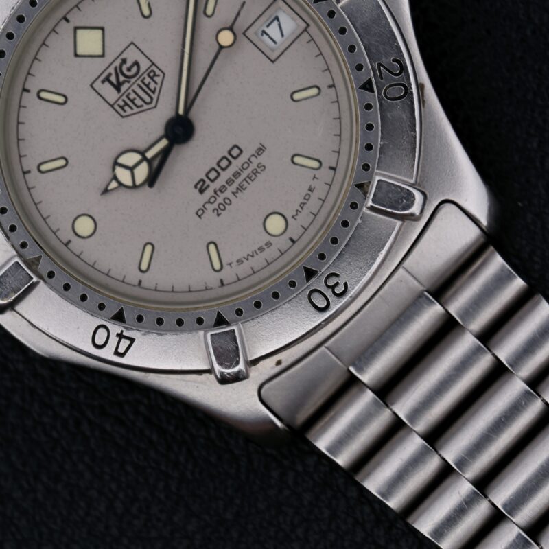 The Tag Heuer Professional 2000 Ref 962.206 is a Swiss-made quartz watch from the 1990s, featuring a 38mm stainless steel case and original stainless steel bracelet. Its gray dial with silver-toned hands and indices ensures readability, while the central seconds hand, hack second function, and rotating bezel add precision and functionality. With a 20mm lug width, it offers a comfortable fit and a minimalist, uncluttered design, making it a versatile and stylish choice for both daily wear and special occasions.