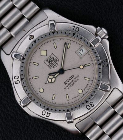 The Tag Heuer Professional 2000 Ref 962.206 is a Swiss-made quartz watch from the 1990s, featuring a 38mm stainless steel case and original stainless steel bracelet. Its gray dial with silver-toned hands and indices ensures readability, while the central seconds hand, hack second function, and rotating bezel add precision and functionality. With a 20mm lug width, it offers a comfortable fit and a minimalist, uncluttered design, making it a versatile and stylish choice for both daily wear and special occasions.