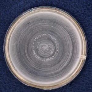 A close-up of the Benrus Day/Date Pointer watchs interior case back shows a metallic, slightly worn surface. The engraving reads Cased and Timed in U.S.A. The Benrus Watch Co. with a stylized logo at the center.