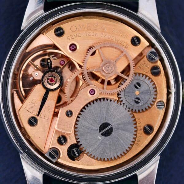 A close-up of the Omega Seamaster 30 Caliber 286 reveals intricate mechanical gears, prominently displaying the brand name and Seventeen 17 Jewels, while serial numbers are etched into the metal surface.