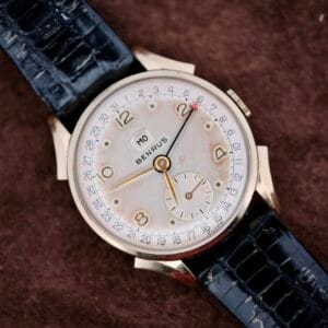 The Benrus Day/Date Pointer features a black leather band and gold numerals on a brown textured dial—an ideal vintage wristwatch for collectors seeking timeless style.