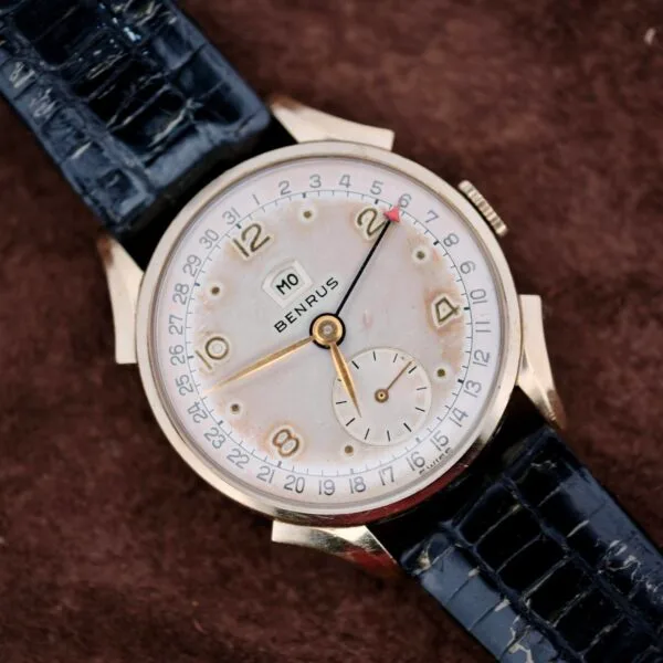 The Benrus Day/Date Pointer features a black leather band and gold numerals on a brown textured dial—an ideal vintage wristwatch for collectors seeking timeless style.
