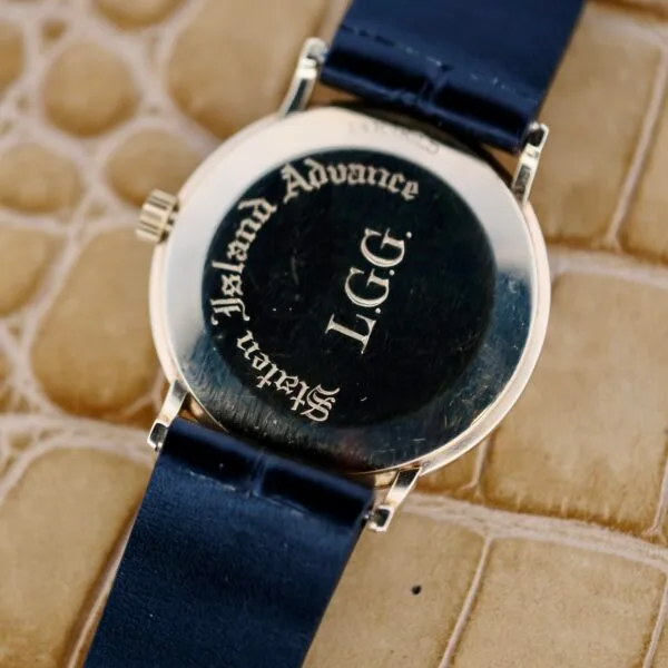 The image shows the back of the Tiffany & Co Arabic Numerals Dial T-101 wristwatch with a black leather strap. Engraved text reads Advance, L.G.G, and Swiss Made. The watch rests on a reptile skin-patterned surface, exuding Tiffany & Cos signature sophistication.