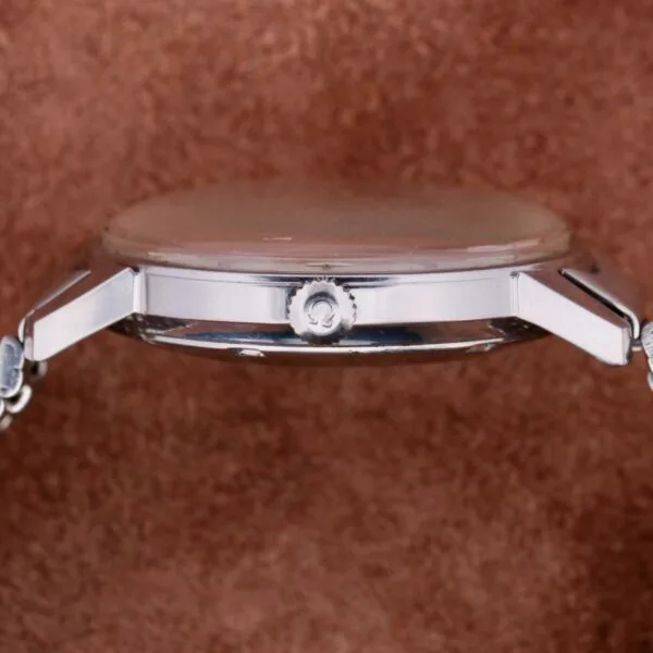 Side view of the Omega Seamaster Automatic Date wristwatch, featuring a silver metallic strap, slim design, round crown, and automatic date display against a brown textured background.