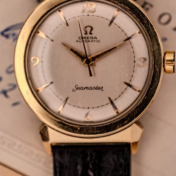 Close-up of an Omega Seamaster Automatic Ref. 14350-2 Bull Horn Lugs wristwatch with a gold case and black leather strap.