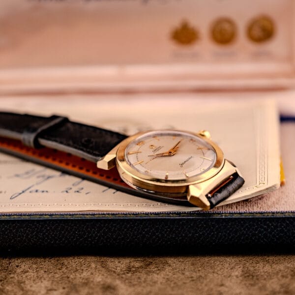 An elegant Omega Seamaster Automatic Ref. 14350-2 Bull Horn Lugs with a black leather strap rests on a handwritten letter, highlighting the timeless charm of the Omega Seamaster collection.