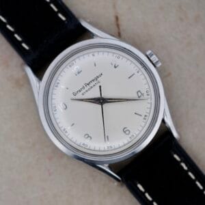 A vintage Girard Perregaux Gyromatic 6169 Caliber 47 wristwatch with a classic white dial and elegant black leather strap.