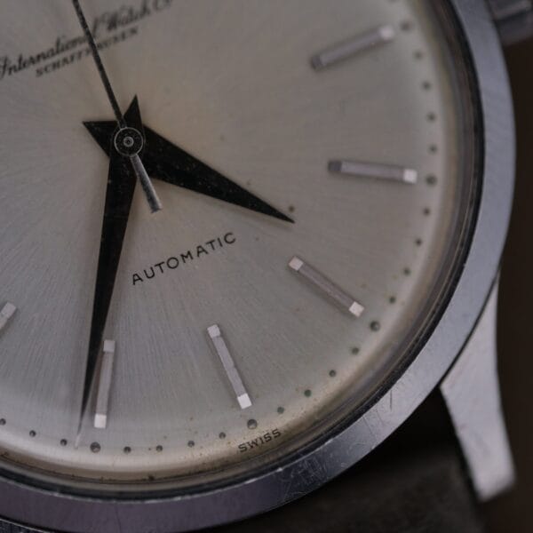 Close-up of the 1960s IWC Automatic Dress Watch Cal. 853, showing a round dial with silver hour markers, the International Watch Co Schaffhausen branding, AUTOMATIC, SWISS at the bottom, and hands set to 9:00.