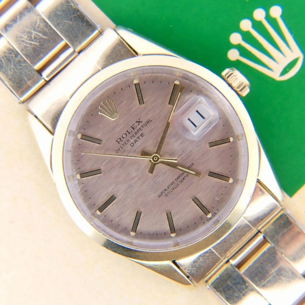 A close-up of a 1978 Rolex 1550 Oyster Perpetual Date 14k Gold Shell wristwatch with a date display and the Rolex logo on a green background.