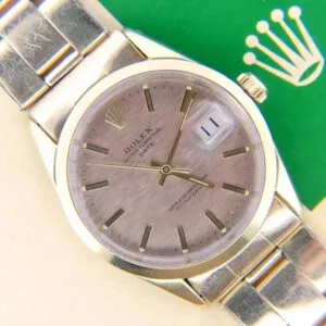 A close-up of a 1978 Rolex 1550 Oyster Perpetual Date 14k Gold Shell wristwatch with a date display and the Rolex logo on a green background.