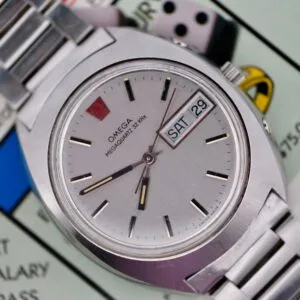 An Omega Megaquartz 32 KHz Day/Date Cal. 1310 wristwatch, showing time, day, and date, rests on a Monopoly game board.