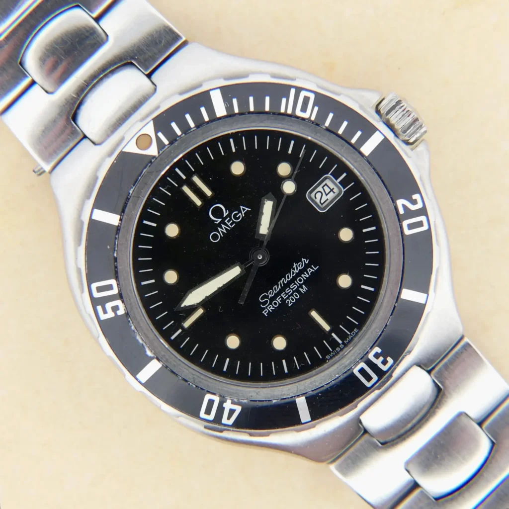 The Omega Seamaster 200M Pre-Bond Ref. 396.1052 features a stainless steel case, black dial with white hour markers, date window at 3 o’clock, and a rotating bezel, displayed against a light background.