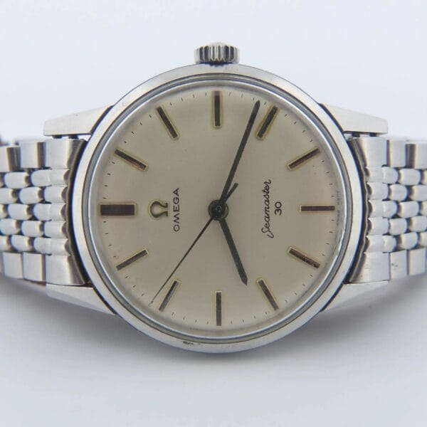 A vintage Omega Seamaster 30 Cal. 286 Reference 135003 wristwatch with a silver metal bracelet, featuring a beige face, black hour markers and hands, and displaying the Omega symbol alongside OMEGA and Seamaster 30.
