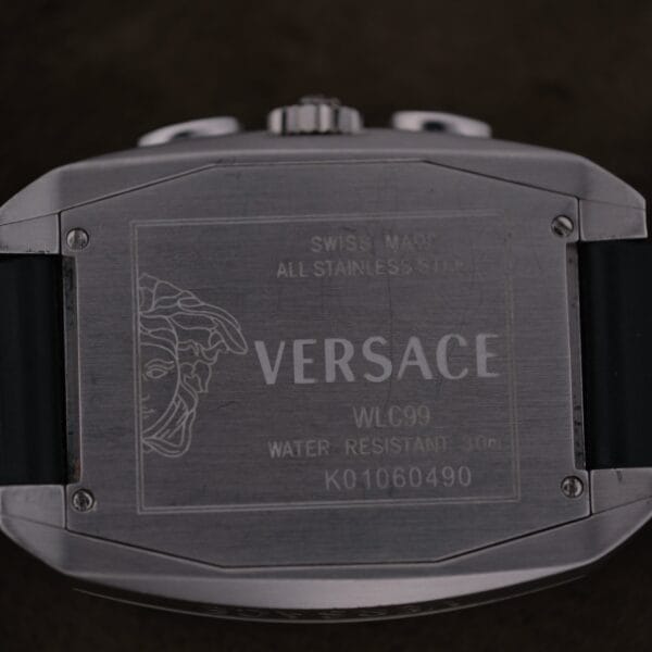 Close-up of the back of a Versace Character Tonneau Swiss Made Chronograph, showing engraved details like the Versace logo, Medusa head, and information: Swiss Made, Water Resistant 30m, and All Stainless Steel.