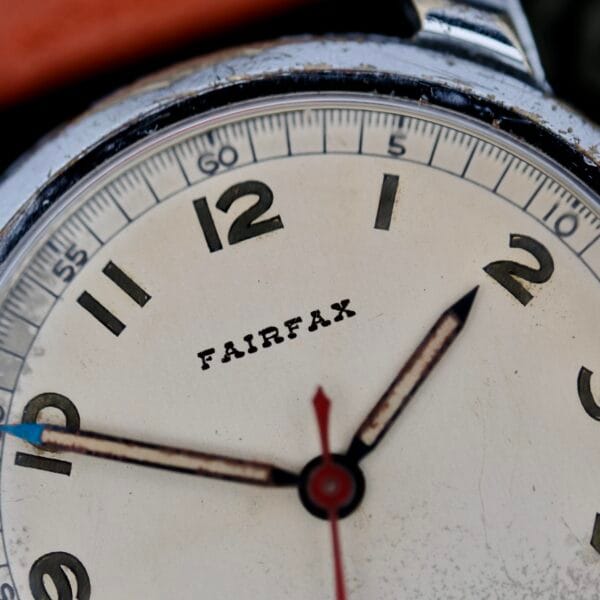 Close-up of a 1940s Fairfax Military Incabloc Manual Wind watch showing approx. 11:09:36, with a worn, slightly dirty face and metallic bezel.