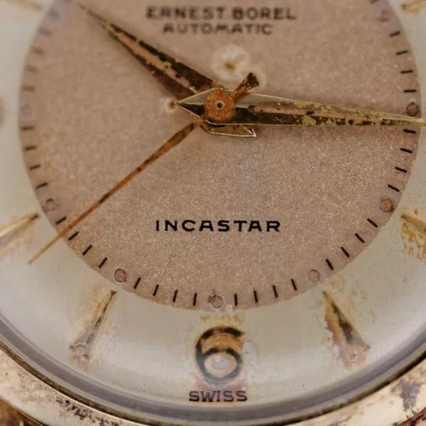 Close-up of the Ernest Borel Incastar 1560 Gold Capped watch face, displaying hour, minute, and second hands with visible wear on the dial. The words ERNEST BOREL AUTOMATIC, INCASTAR, and SWISS appear.