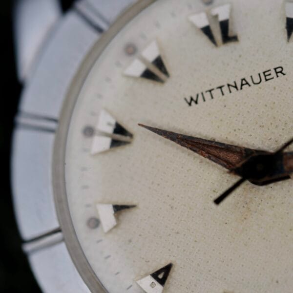 Close-up of the Wittnauer 2065 Waffle Dial, featuring Art Deco indices, brand name, textured off-white dial, triangular hour markers, and brown hour and minute hands.