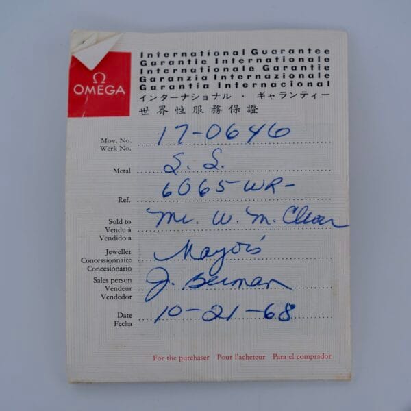 A 1968 Omega Seamaster Deville 165.020 International Guarantee card featuring handwritten details—numbers, Mr. W. McClain, Mayor, J. Berman, and the date 10-21-68—set against a neutral background.