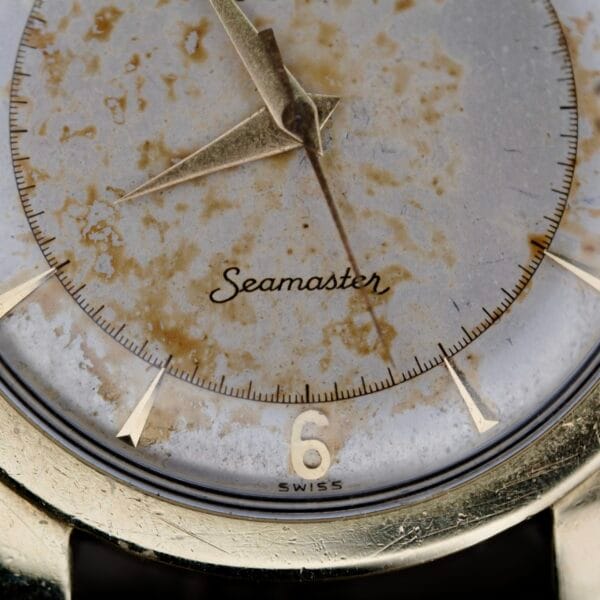 Close-up of an Omega Seamaster Automatic 2577-17 Tropic Dial showing patina and discoloration on the dial, gold hands and indices, Seamaster, and the number 6 with SWISS below.