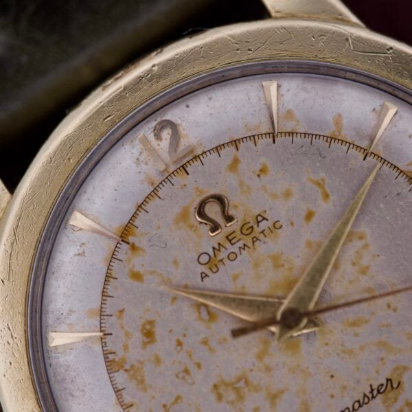 Close-up of an Omega Seamaster Automatic 2577-17 featuring a worn, tarnished Tropic Dial and gold hour markers.