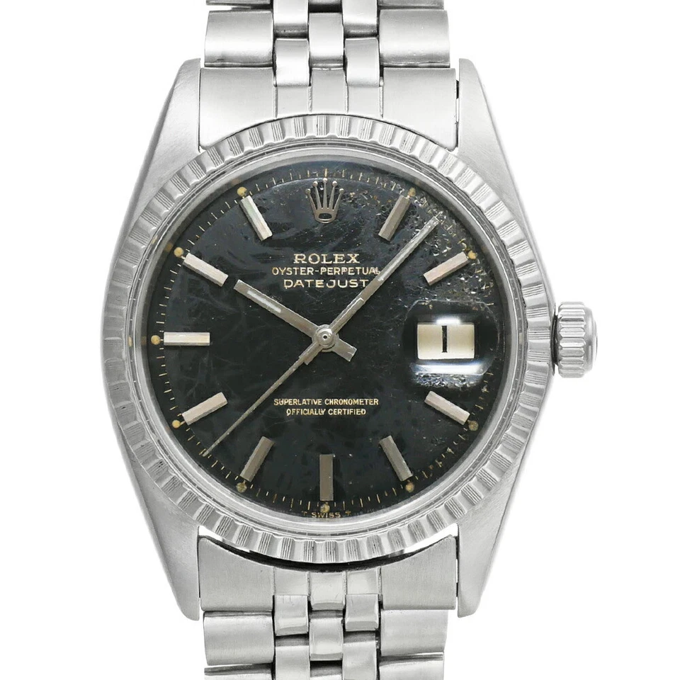 A stainless steel Rolex Datejust 1603 wristwatch with a black dial, silver hour markers, date window at 3 oclock, and Jubilee bracelet. The watch shows visible signs of wear on the dial.