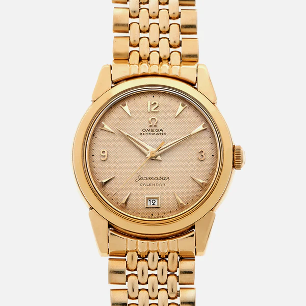A gold Omega Seamaster 2627 Calendar wristwatch with a gold metal link band, round gold dial, gold hour markers, and a date window at the 6 oclock position.