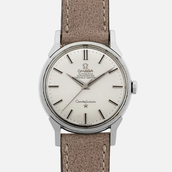 A silver Omega Constellation 167.005 wristwatch with a beige leather strap, white dial, black hour markers, and silver hands. The watch face displays Omega Automatic Chronometer Officially Certified.