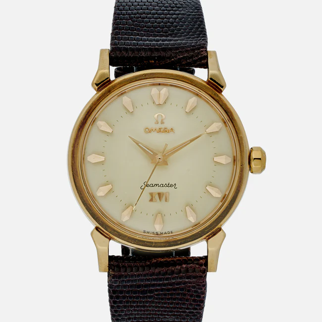 A vintage Omega Seamaster 2850 SC wristwatch with a gold case, cream dial, gold hour markers and hands, and a dark textured leather strap. The dial features the Omega logo, Seamaster, and Swiss Made text.