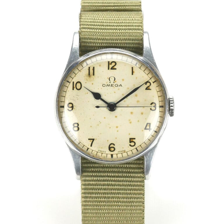 A vintage Omega 6B/159 1943 Issue wristwatch featuring a round, off-white dial with patina, bold black numerals, and two hands in a silver case, paired with a textured khaki fabric strap. The Omega logo sits below the 12 o’clock position.