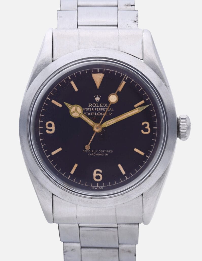 A vintage Rolex Explorer 6610 Oyster Perpetual watch featuring a classic black dial and sleek silver metal band.