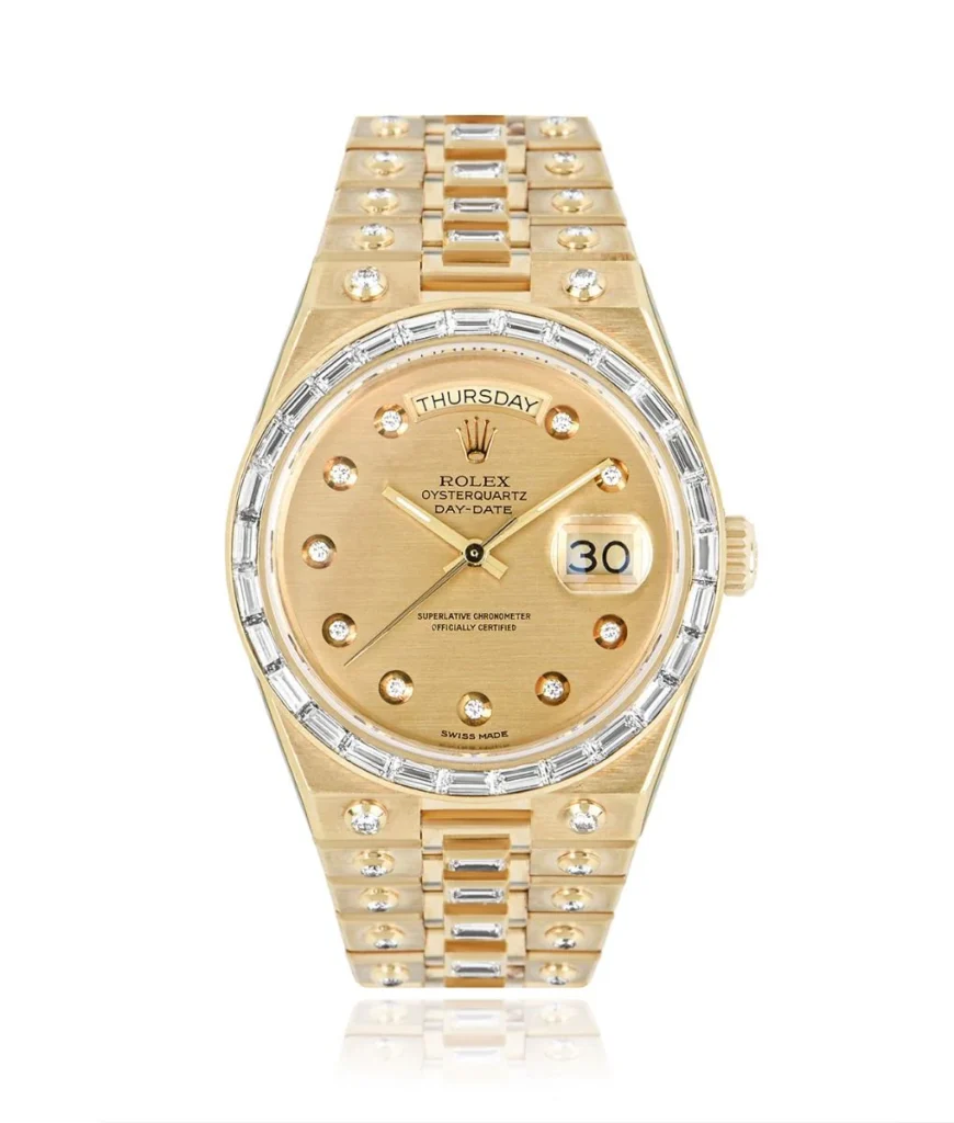 Gold Rolex Oysterquartz Day-Date watch with diamond hour markers, a baguette diamond bezel, and day-date display on the face. Model 19168.