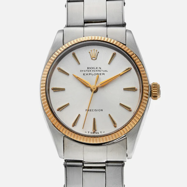 A silver Rolex Explorer 5501 watch with a gold bezel, white dial, and gold hour markers on a metal band.