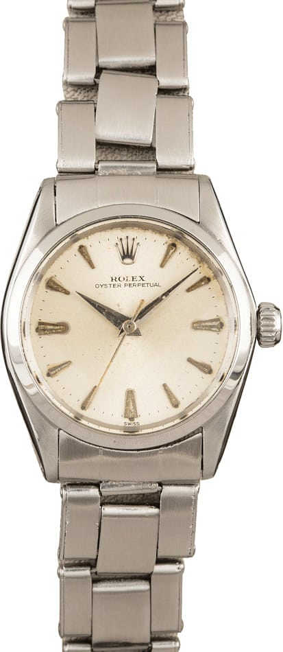 A silver Rolex Oyster Perpetual 6548 wristwatch with a metal band and a cream-colored dial.