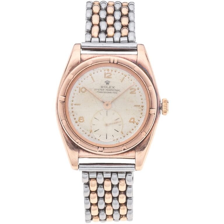 Vintage Rolex Oyster Perpetual wristwatch with a gold and silver metal band and a round, worn white dial.
