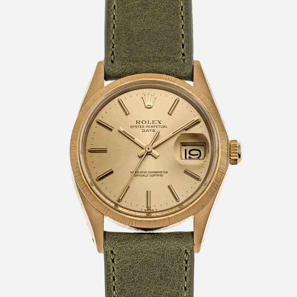 Gold Rolex Oyster Perpetual watch with date display, green leather strap, and minimalist hour markers on a beige dial.