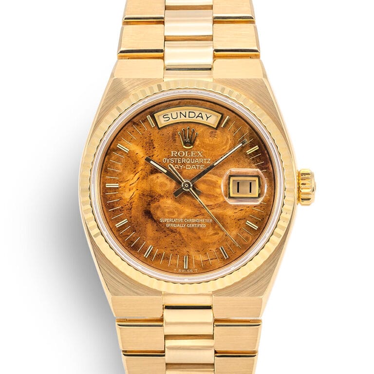 Gold Rolex Oysterquartz Day-Date 19068 watch featuring a brown marbled dial with day and date displays.