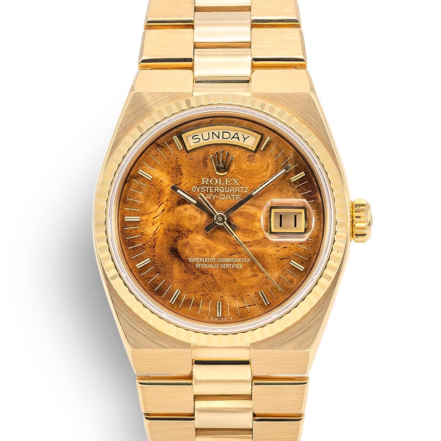 Gold Rolex Oysterquartz Day-Date 19068 watch featuring a brown marbled dial with day and date displays.