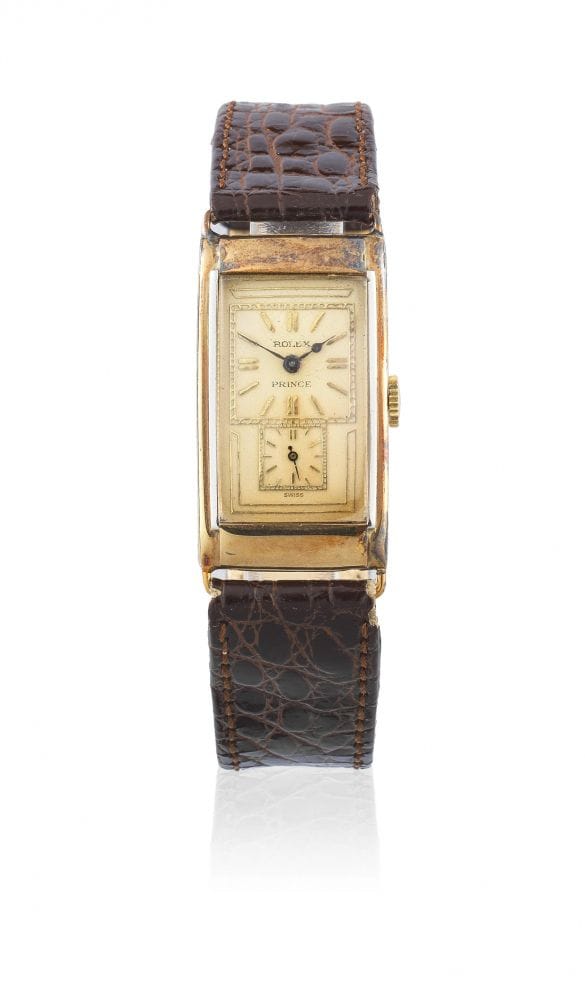 Vintage gold rectangular wristwatch inspired by the Rolex Prince, with a brown leather strap and a small subdial above 6 o’clock.