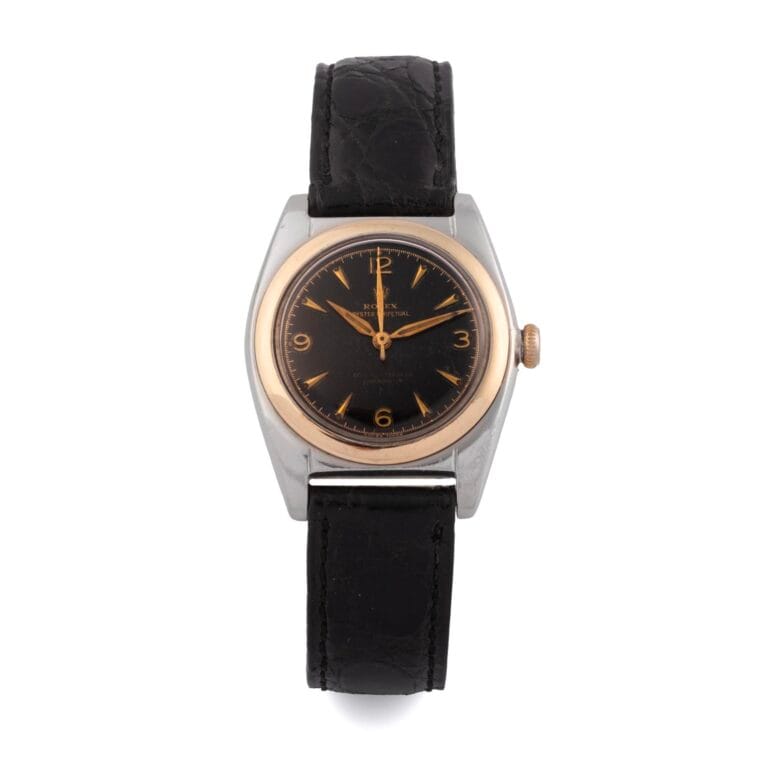 Vintage Rolex Oyster Perpetual 4937 wristwatch with a black leather strap, black dial, gold hands, and a round silver and gold casing.