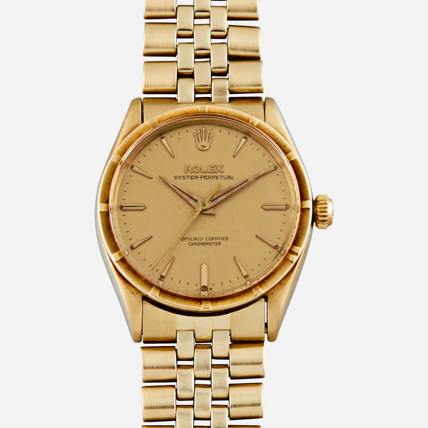 Gold Rolex Oyster Perpetual 6569 watch featuring a gold face, simple hour markers, and a classic metal link bracelet.