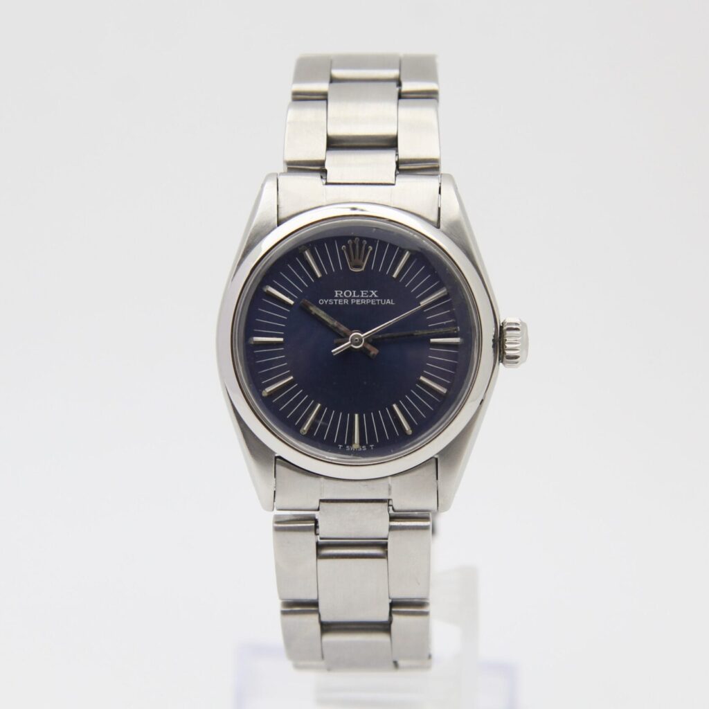 A stainless steel Rolex Oyster Perpetual 6749 watch with a dark blue dial on a metal bracelet, displayed upright.