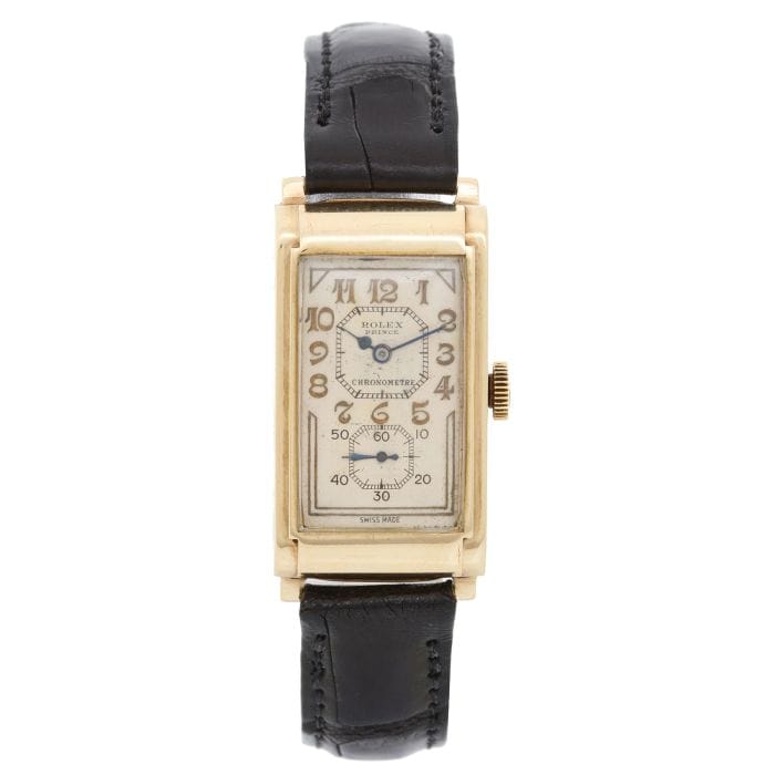 A vintage rectangular Rolex Prince wristwatch with a black leather strap and gold case, reminiscent of classic Railway L 862 designs.