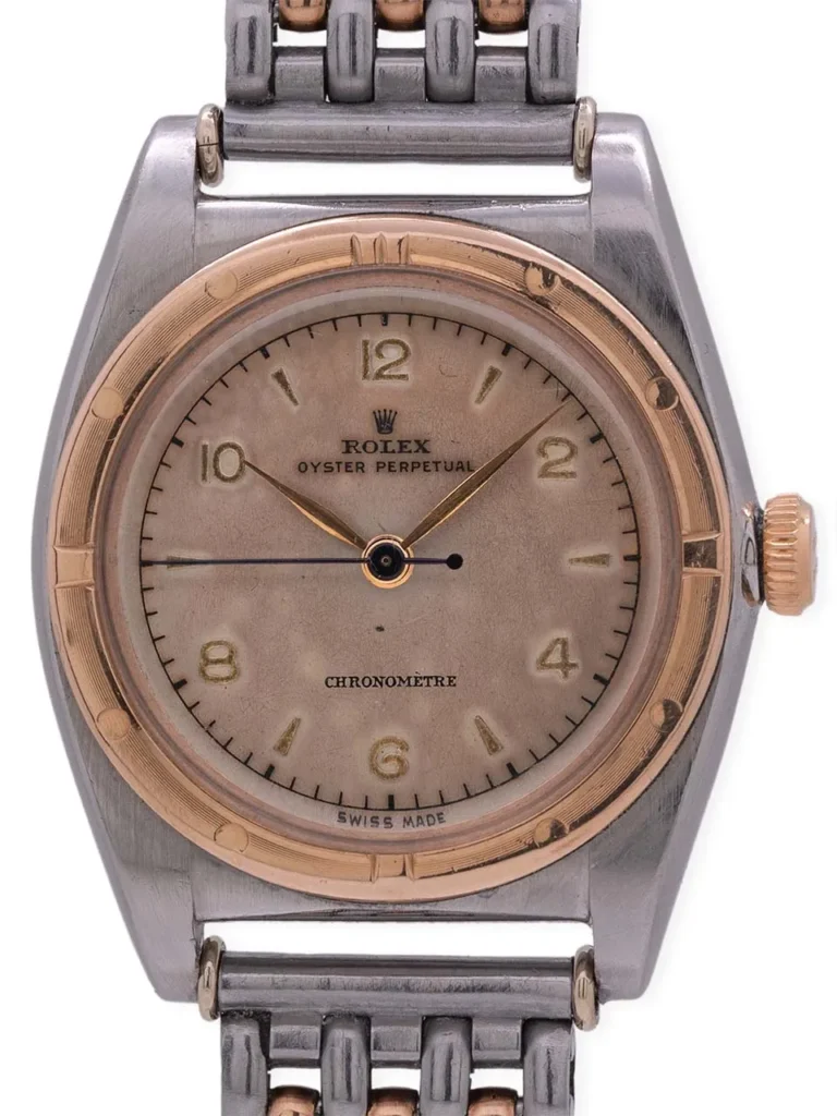 A vintage Rolex Oyster Perpetual 3272 watch with a two-tone metal case and bracelet, displaying gold hour markers.