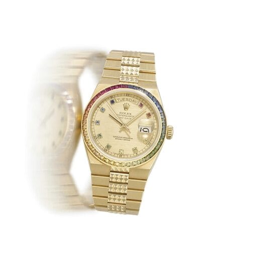 Gold Rolex Oysterquartz Day-Date wristwatch, model 19078, with a gemstone bezel and a blurred duplicate image to its left on a white background.