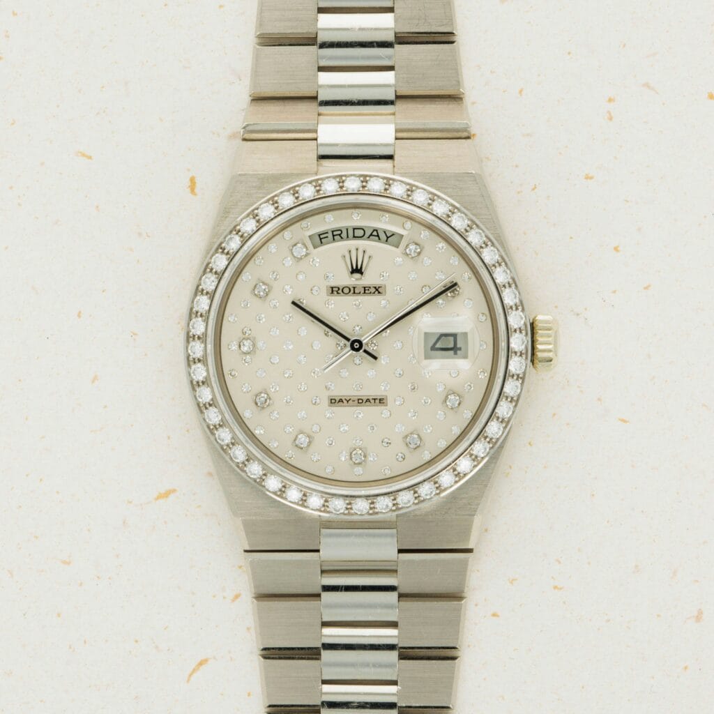 Silver Rolex Oysterquartz Day-Date watch with a diamond-studded face, day and date displays, and a two-tone metal bracelet.