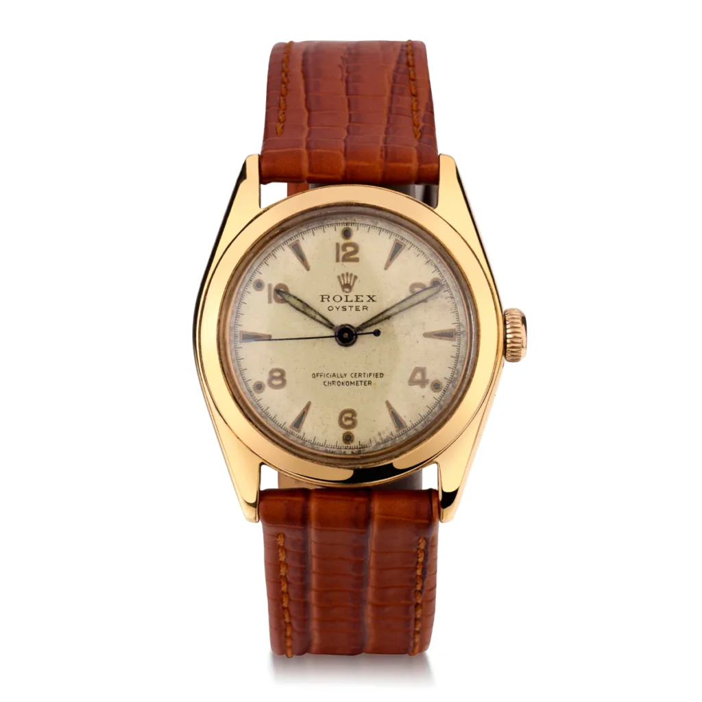 Gold Rolex Oyster 5020 watch with a brown leather strap and a white dial featuring Arabic numerals and markers.