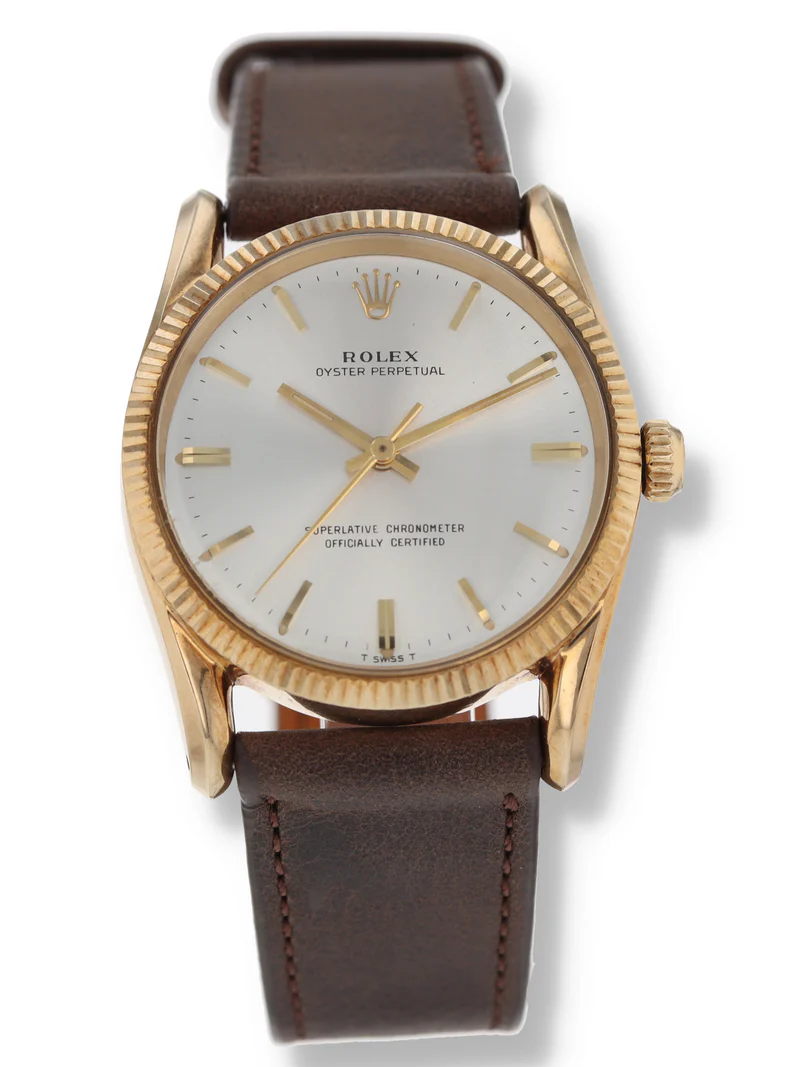 Gold Rolex Oyster Perpetual 1011 watch with a white dial and brown leather strap, viewed from above.